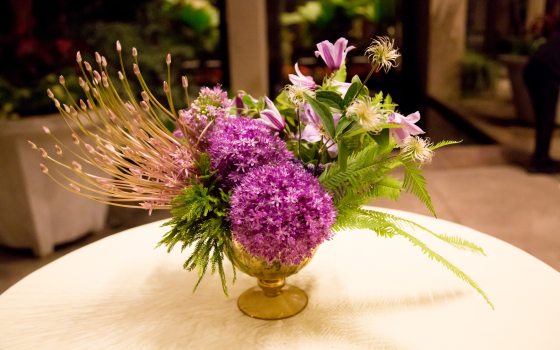 A vase of purple flowers on a table. 